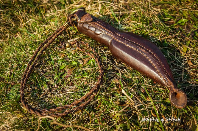 Small Puukko knife with leather sheath on grass in sunlight. Colour Landscape. © P. Maton 2015 whittleandstitch.net